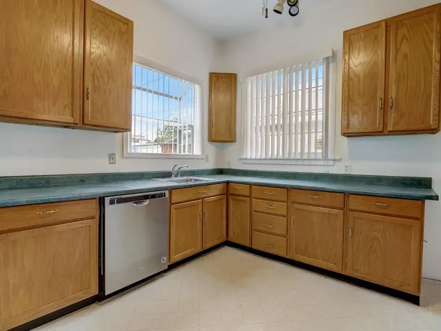 a kitchen with granite countertop cabinets sink and window