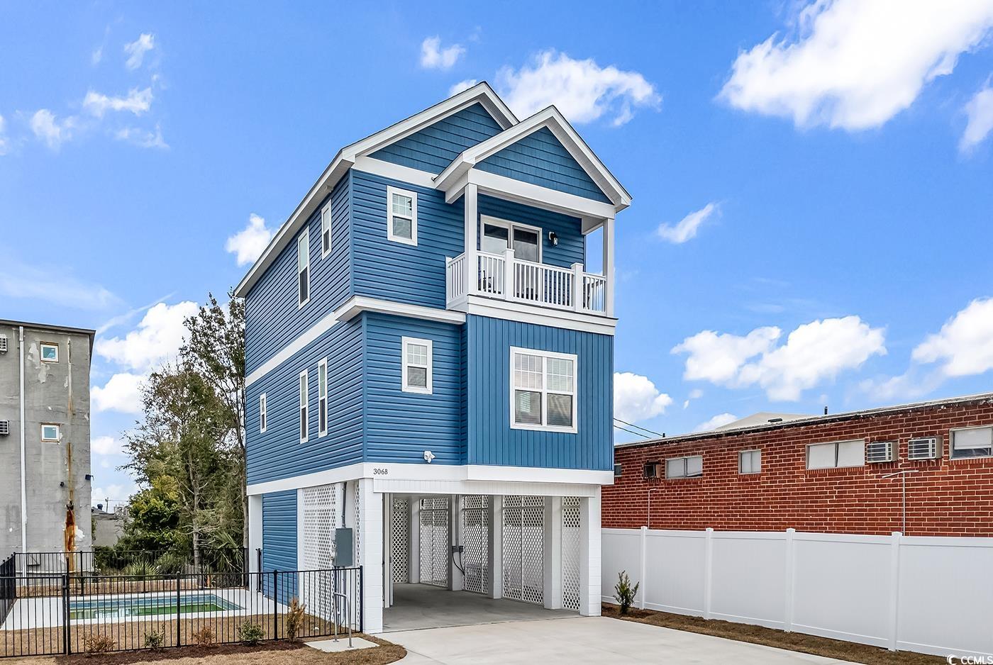 View of front of house featuring a carport, driveway, and a balcony