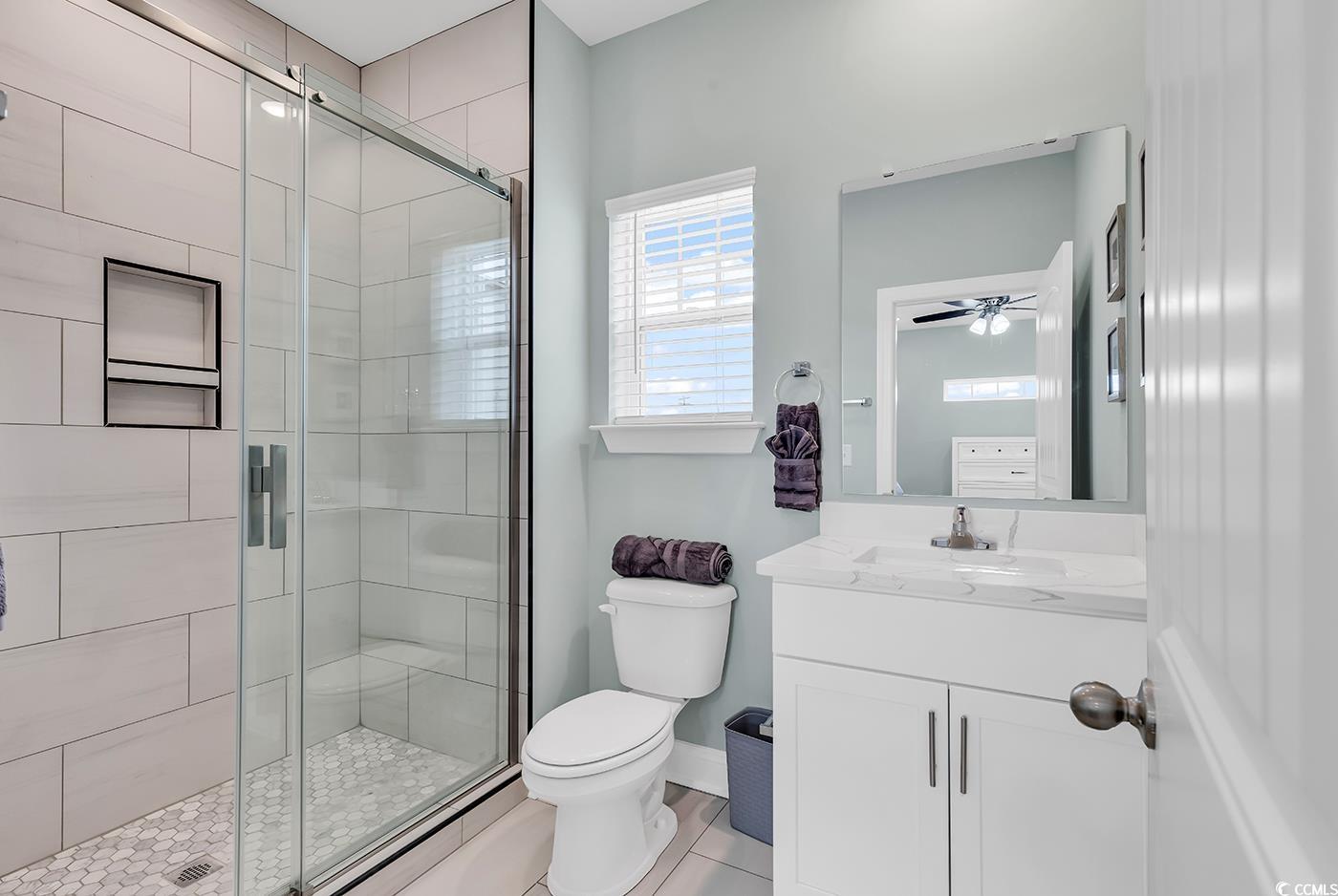 306 6th Avenue North Myrtle Beach, SC 29577 - Photo 14 of 28 Bathroom with a shower stall, vanity, light tile patterned floors, and a ceiling fan