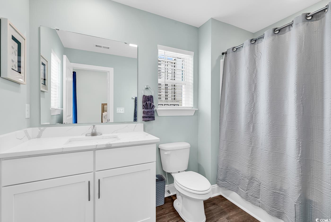 306 6th Avenue North Myrtle Beach, SC 29577 - Photo 16 of 28 Bathroom with vanity, dark wood-type flooring, and shower / bath combination with curtain