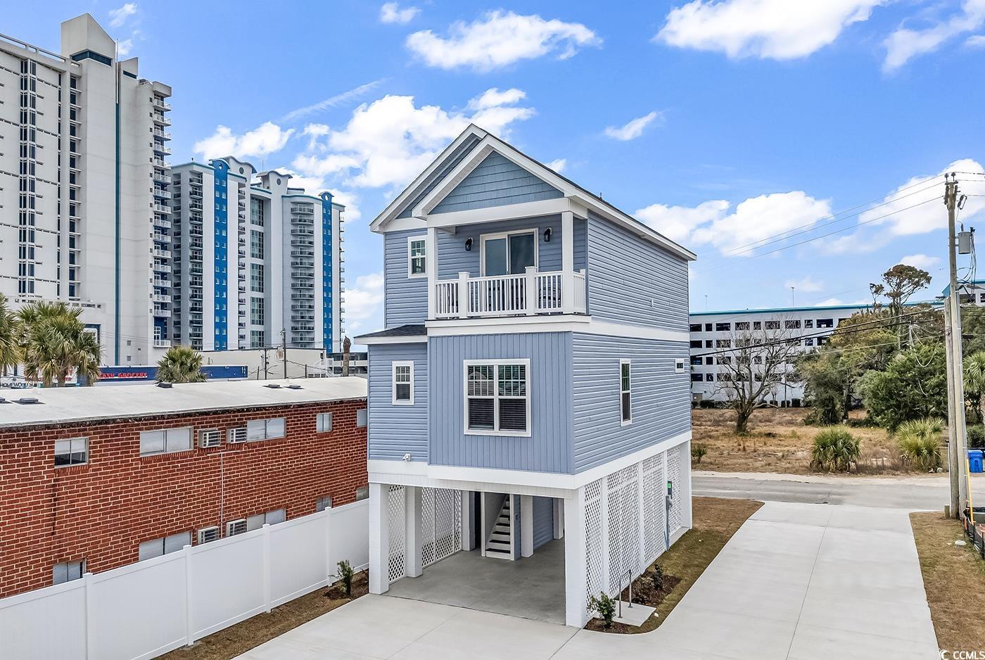 306 6th Avenue North Myrtle Beach, SC 29577 - Photo 2 of 28 View of side of property with a carport, concrete driveway, and a balcony
