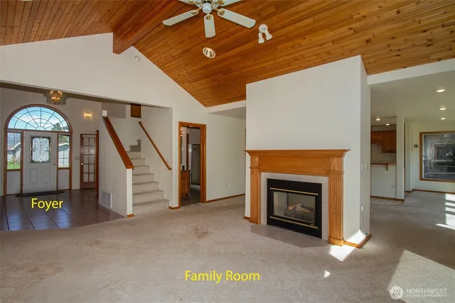 an empty room with furniture staircase and a fireplace