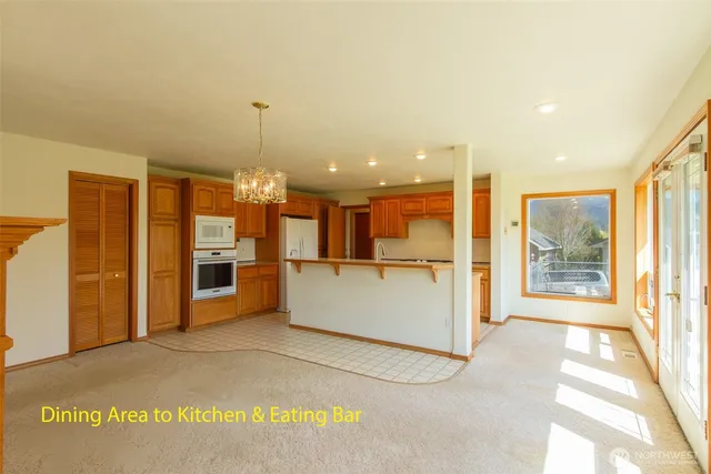 a view of a kitchen with refrigerator and windows
