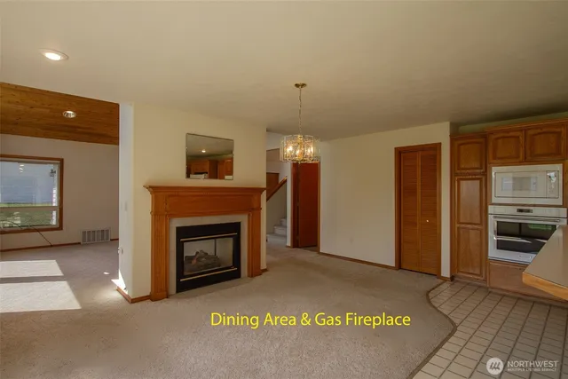 a view of a livingroom with a fireplace and a kitchen