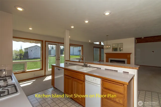 a kitchen with a stove a counter top space and a large window