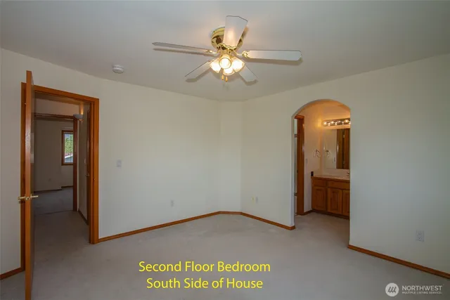 a view of a livingroom with a chandelier fan and hardwood floor