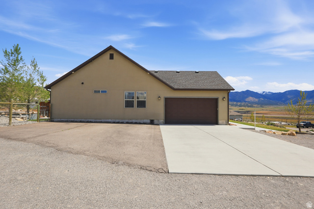 1588 West Rim Rock Drive Stockton, UT 84071 - Photo 51 of 61 Single-story residence featuring a two-car garage, concrete driveway, and a gravel parking area