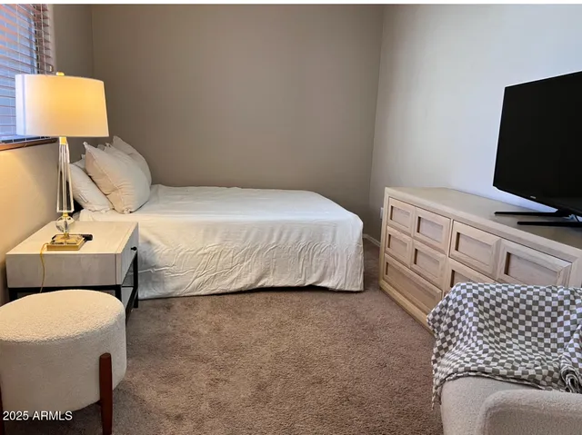 a bedroom with a bed and flat screen tv