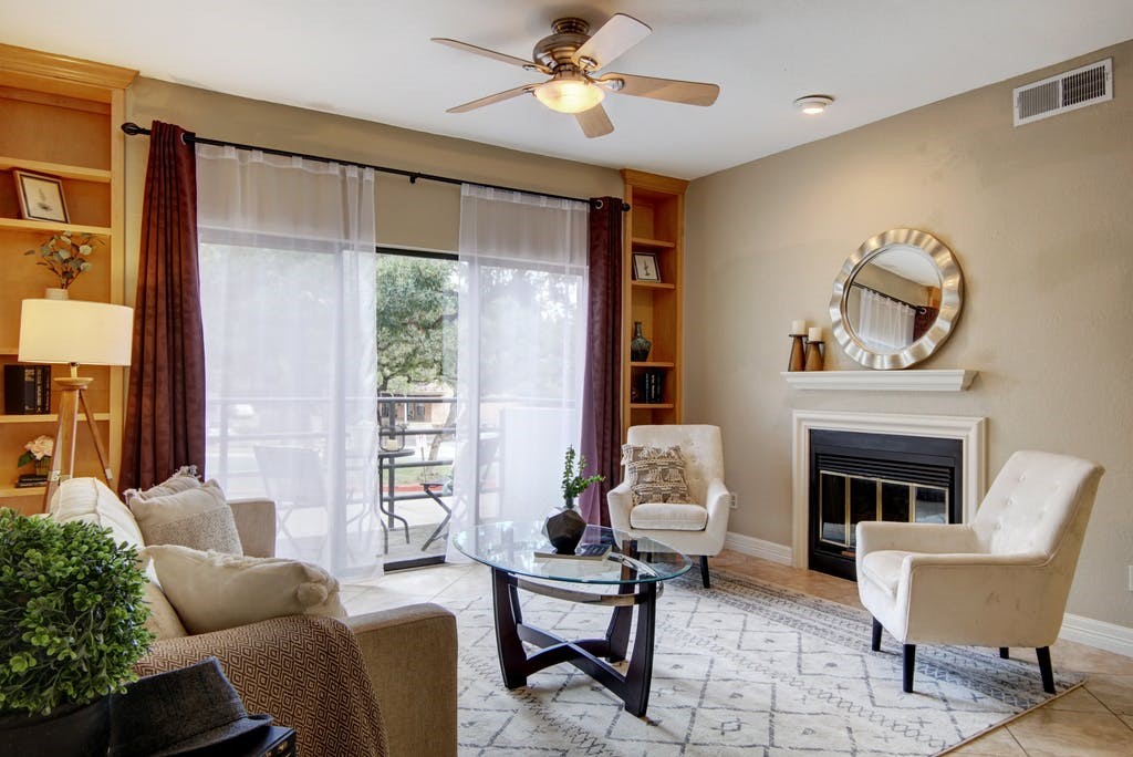 a living room with furniture a fireplace and a chandelier