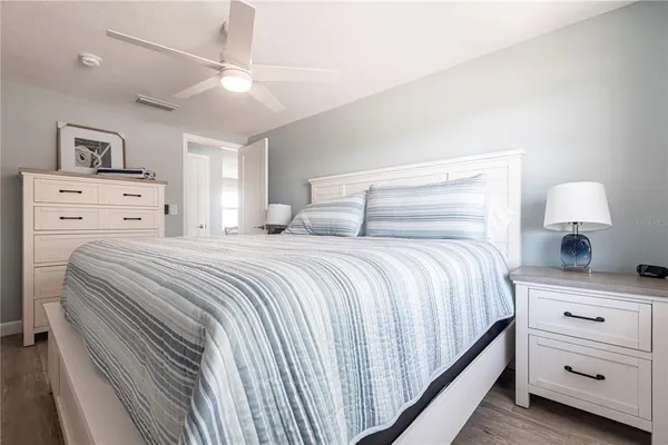 a bedroom with a bed and a lamp on the dresser