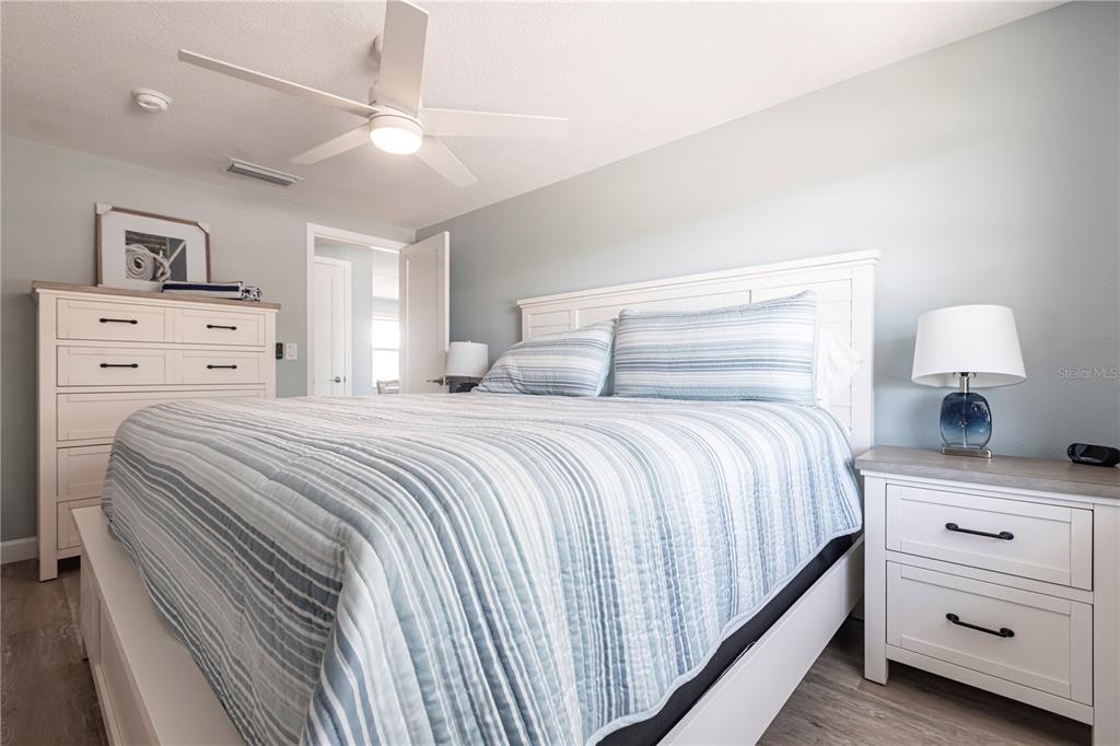 6020 Midnight Pass Road, Unit 53 Sarasota, FL 34242 - Photo 11 of 16 a bedroom with a bed and a lamp on the dresser