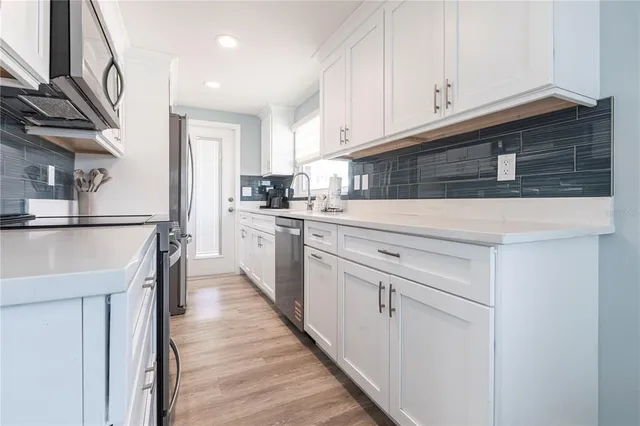 a kitchen with white cabinets and sink
