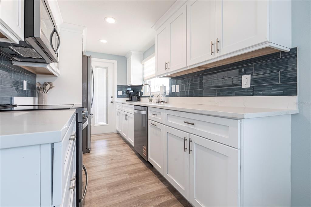 6020 Midnight Pass Road, Unit 53 Sarasota, FL 34242 - Photo 9 of 16 a kitchen with white cabinets and sink