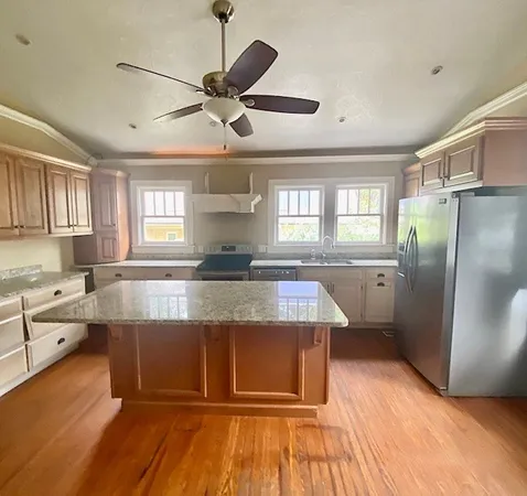 a view of a room with wooden floor chandelier and a window