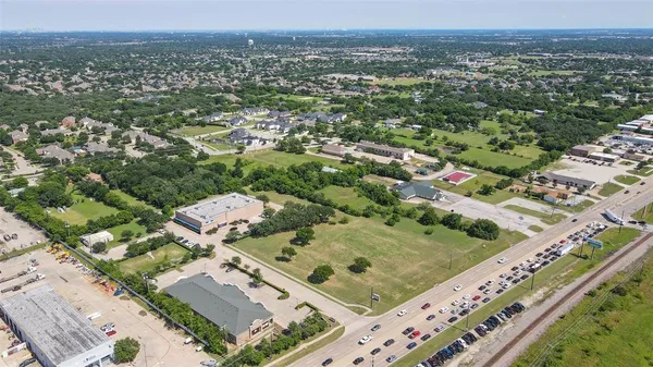 an aerial view of residential houses with outdoor space and ocean view