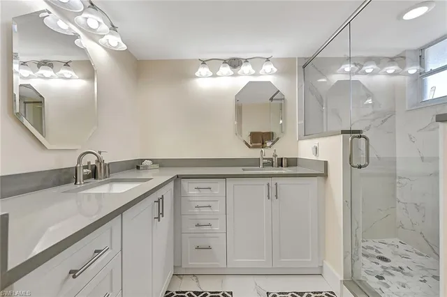 a bathroom with a double vanity sink mirror and shower