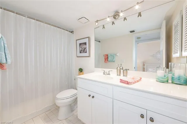 a bathroom with a granite countertop sink a toilet and a mirror