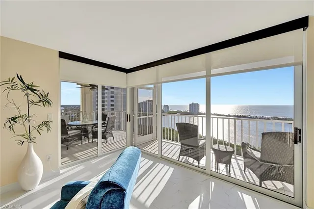 a living room with furniture and a floor to ceiling window