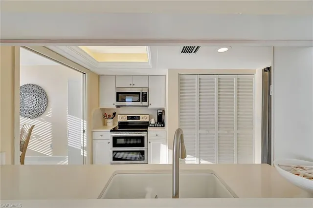 a kitchen with stainless steel appliances kitchen island granite countertop a refrigerator and a sink