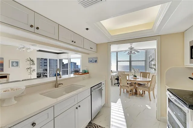 a dining hall with stainless steel appliances granite countertop a sink and dishwasher with wooden floor