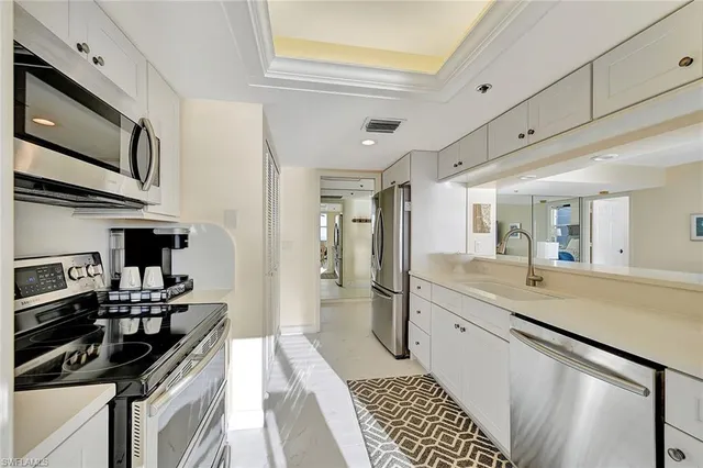 a kitchen with stainless steel appliances a sink stove and cabinets