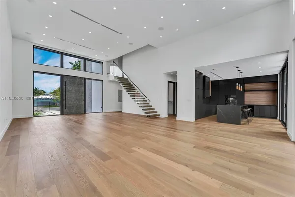 a kitchen with stainless steel appliances granite countertop a sink a stove and a wooden floor