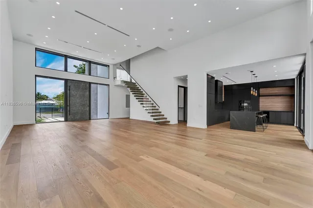 a kitchen with stainless steel appliances granite countertop a sink a stove and a wooden floor