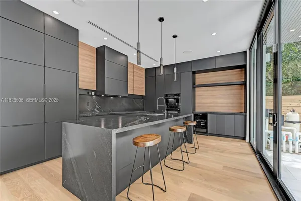 a kitchen with stainless steel appliances granite countertop a sink a stove and a refrigerator