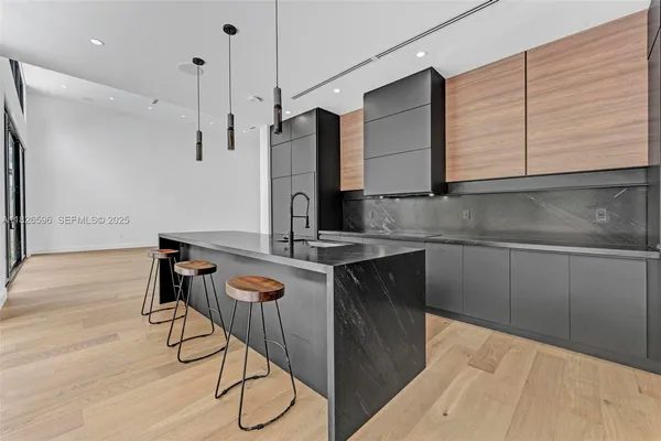 a view of an empty room with wooden floor and a large window