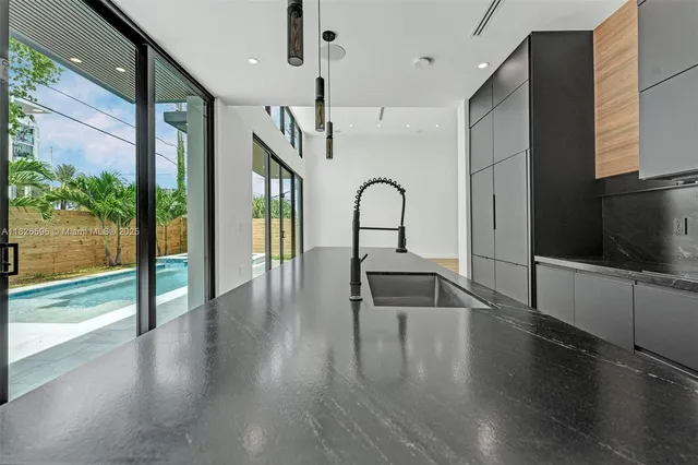 a view of an empty room with wooden floor and a large window