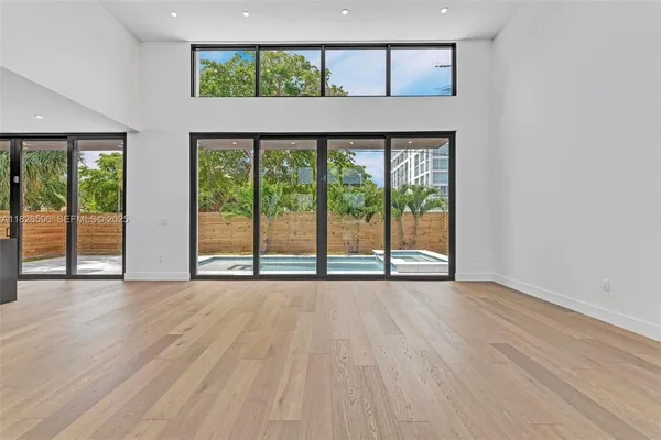 a large kitchen with kitchen island a large window cabinets and stainless steel appliances