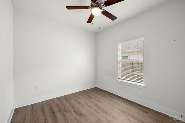an empty room with a window and a fan