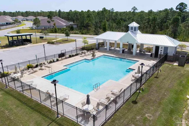 a view of a house with pool and chairs