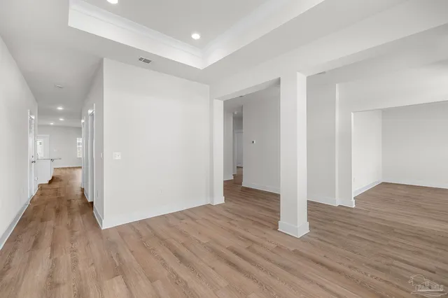 a view of empty room with wooden floor
