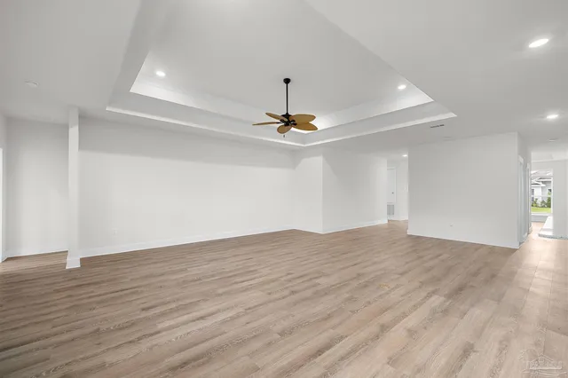 a view of an empty room with wooden floor chandelier