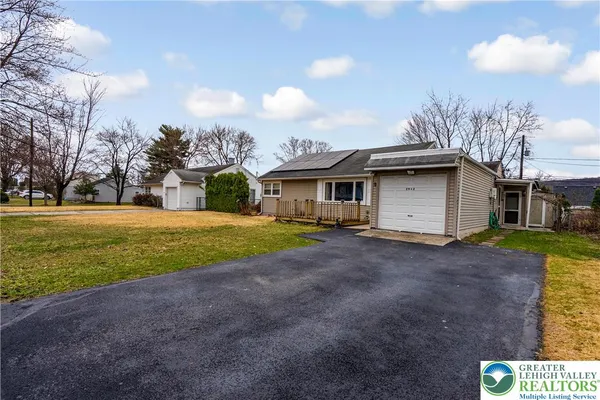 a view of a house with backyard and trees