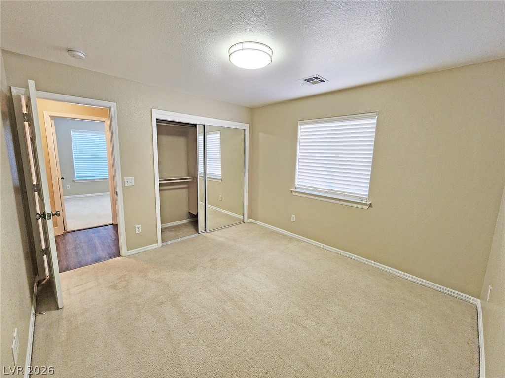 4591 Stoneham Street Pahrump, NV 89061 - Photo 33 of 42 A comfortable bedroom with soft carpeting and a mirrored closet awaits.