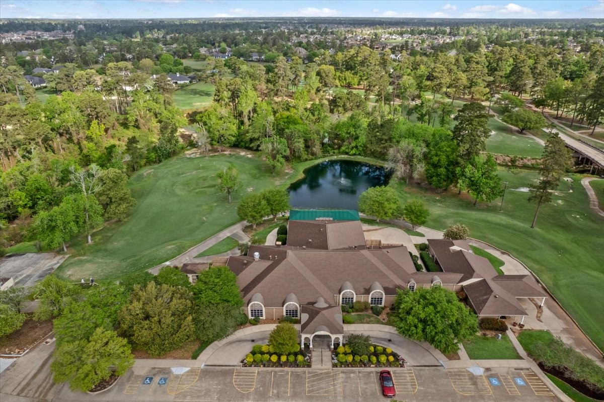 6507 Quiet Pointe Drive Spring, TX 77389 - Photo 41 of 46 This aerial photo showcases a sprawling golf course community with lush greenery. A large clubhouse is centrally located, overlooking a pond and surrounded by well-maintained lawns and trees, offering a serene and picturesque setting.
