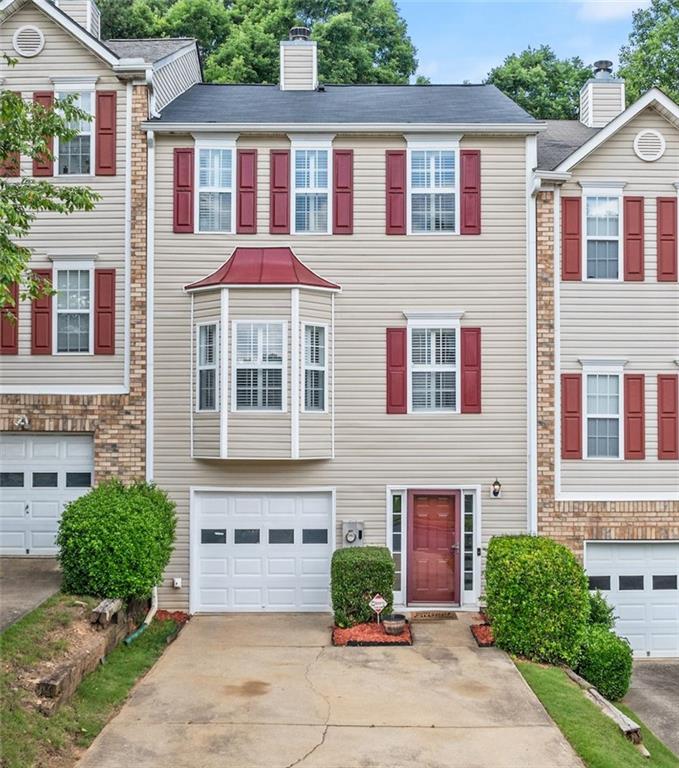 a front view of a house with yard and parking