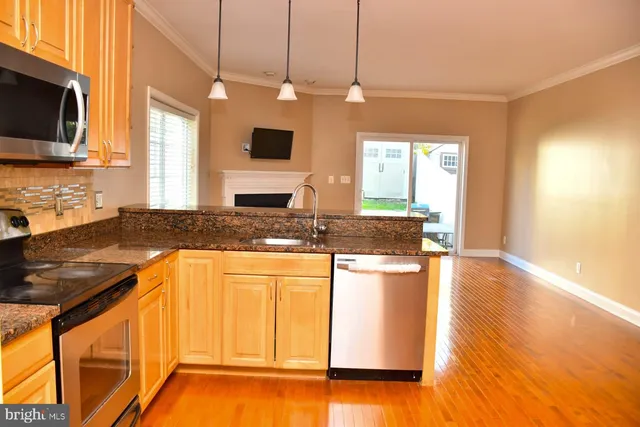 a kitchen with stainless steel appliances granite countertop a sink a stove and a microwave