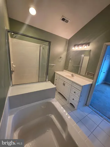 a bathroom with a tub mirror and sink