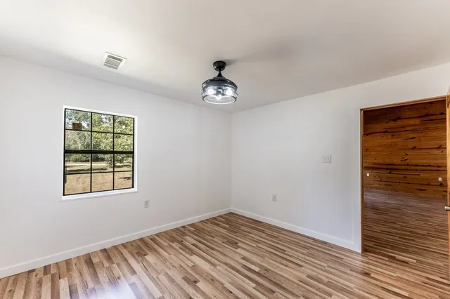 wooden floor in an empty room with a window