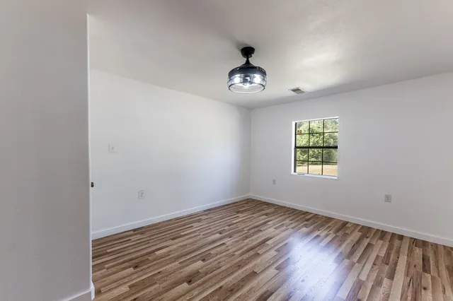 a view of empty room with wooden floor