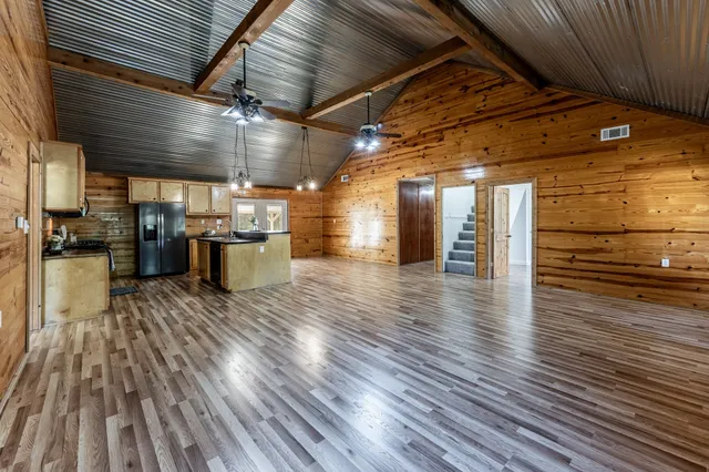 a kitchen with stainless steel appliances granite countertop a sink a stove and a wooden floor