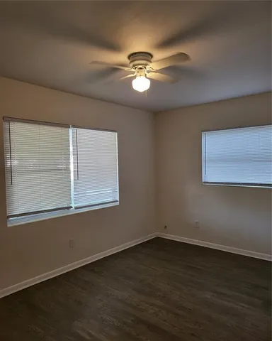 a view of wooden floor and a chandelier fan in a room