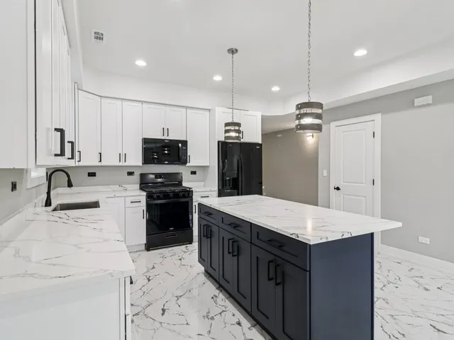 a kitchen with a sink a counter top space stainless steel appliances and cabinets