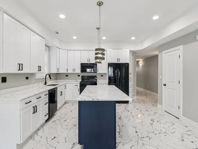 a kitchen with kitchen island white cabinets and wooden floor