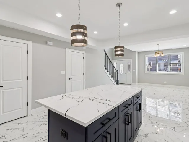 a large kitchen with kitchen island a sink stainless steel appliances and cabinets