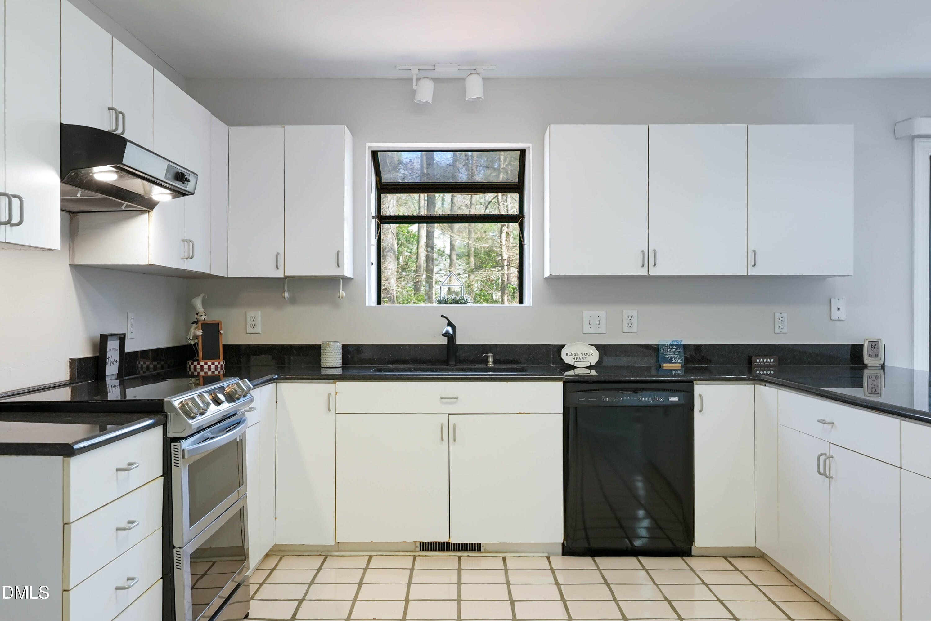 1500 Surfbird Court Raleigh, NC 27615 - Photo 14 of 47 a kitchen with granite countertop a stove sink and cabinets
