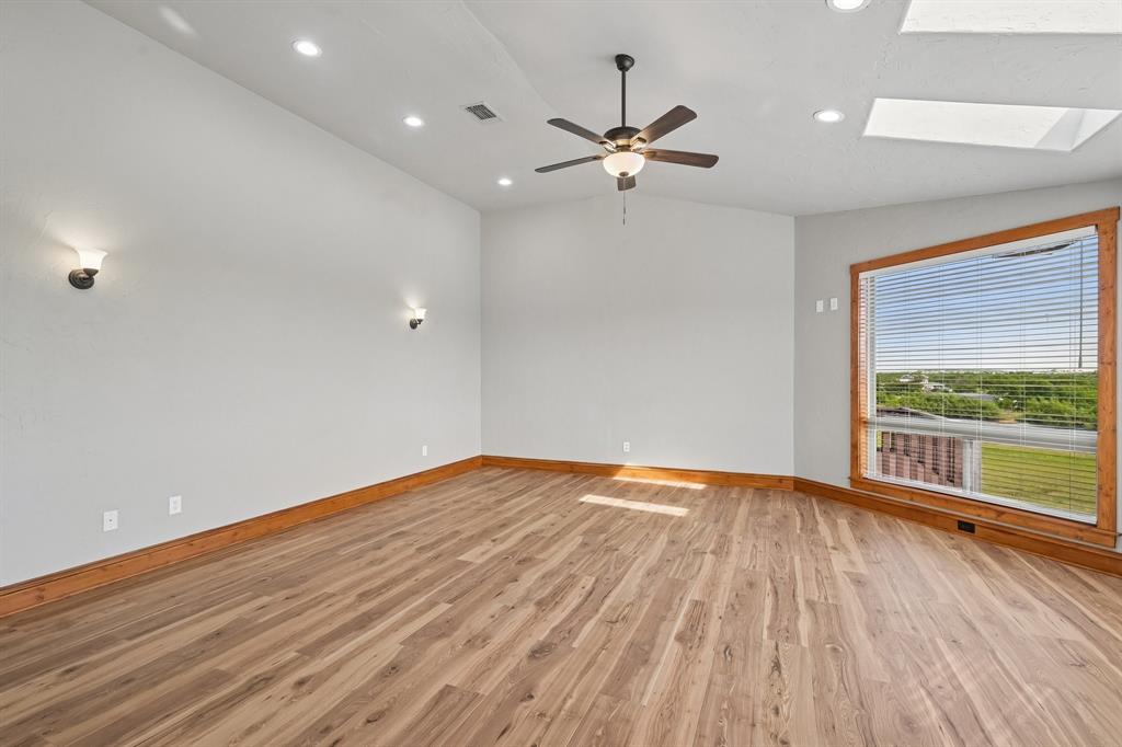 2085 Switzer Road Sanger, TX 76266 - Photo 14 of 39 Spacious room featuring wood-finish flooring, a ceiling fan, recessed lighting, and wall sconces